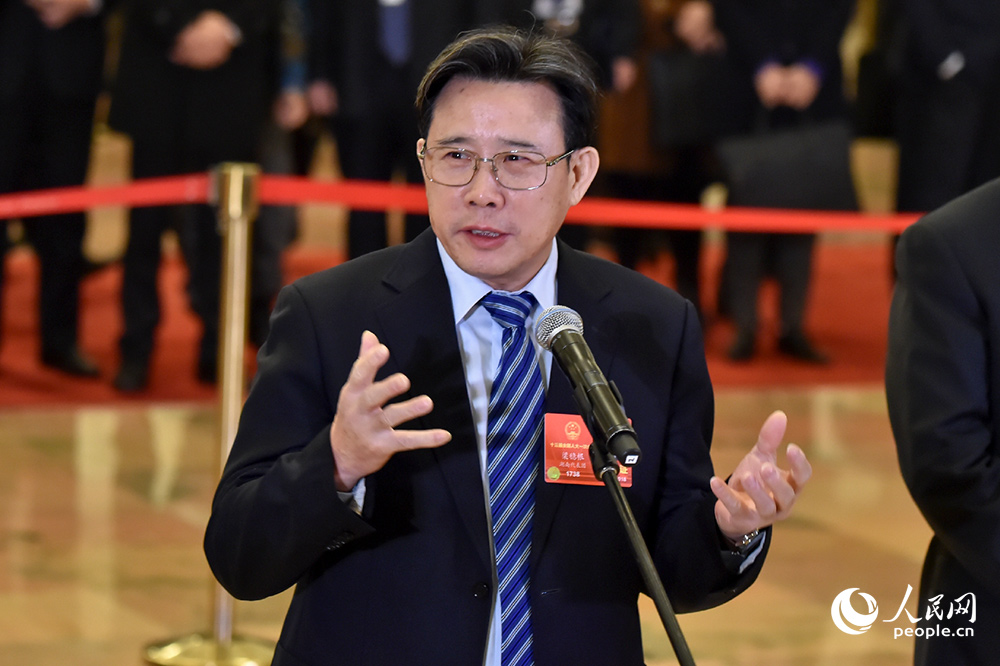 全国人大代表梁稳根在“代表通道”接受采访。人民网记者 翁奇羽 摄 全国人大代表梁稳根在“代表通道”接受采访。人民网记者 翁奇羽 摄